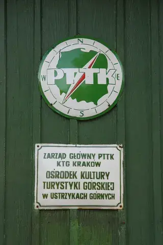 Tablica Ośrodka Kultury Turystyki Górskiej w Ustrzykach Górnych